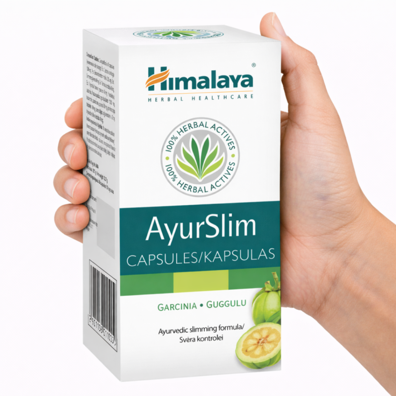 Mano sosteniendo una caja de AyurSlim Himalaya cápsulas sobre fondo blanco.