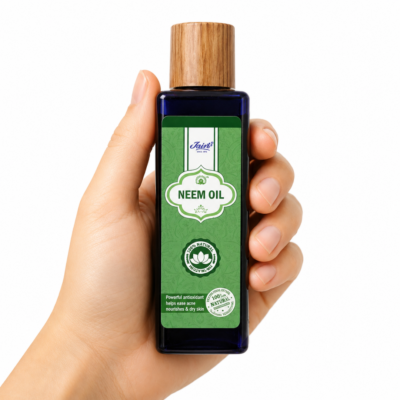 Mano neutra sosteniendo Aceite de Neem Puro de Jains sobre fondo blanco minimalista.
