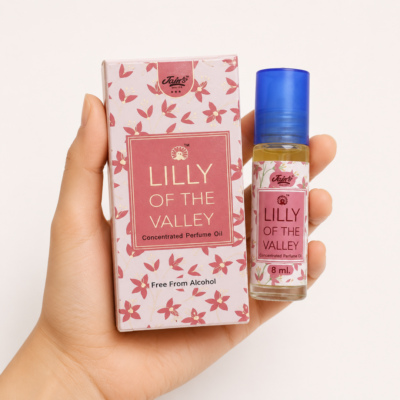 Mano neutra sosteniendo Attar Lilly of the Valley 100% natural de Jains sobre fondo blanco minimalista.