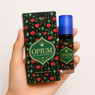 Mano neutra sosteniendo Attar Opium 100% natural de Jains sobre fondo blanco minimalista.