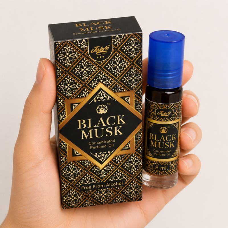 Mano neutra sosteniendo Attar Black Musk 100% natural de Jains sobre fondo beige minimalista.