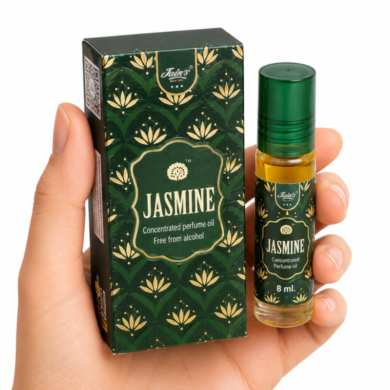 Mano neutra sosteniendo Attar Jasmine 100% natural de Jains con diseño verde floral sobre fondo blanco minimalista.
