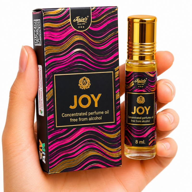 Mano neutra sosteniendo Attar Joy 100% natural de Jains con diseño negro, dorado y magenta sobre fondo blanco minimalista.