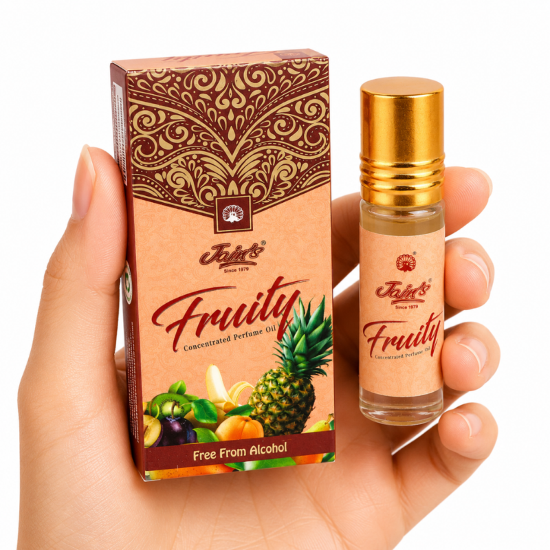 Mano neutra sosteniendo Attar Fruity 100% natural de Jains con diseño tropical afrutado sobre fondo blanco minimalista.