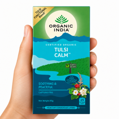 Infusión Tulsi Calm Organic India caja con mano neutra sosteniendo té ayurvédico relajante sin cafeína con rosa manzanilla jazmín