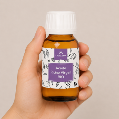 Mano neutra sosteniendo Aceite de Ricino Virgen BIO de Camassia sobre fondo beige minimalista.
