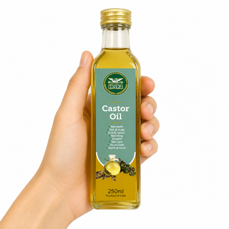 Mano sosteniendo botella de Heera Castor Oil 250ml sobre fondo blanco