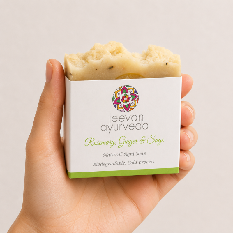 Mano neutra sosteniendo jabón natural Jeevan Ayurveda Rosemary, Ginger & Sage sobre fondo claro minimalista.