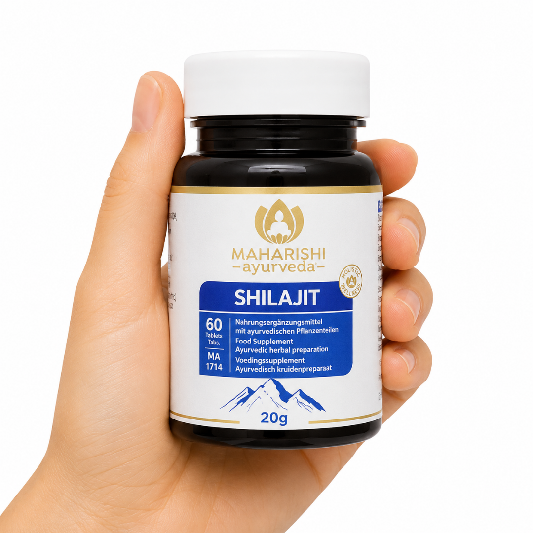 Shilajit 60cap Mano sosteniendo suplemento ayurvédico Maharishi Ayurveda Shilajit en cápsulas sobre fondo neutro