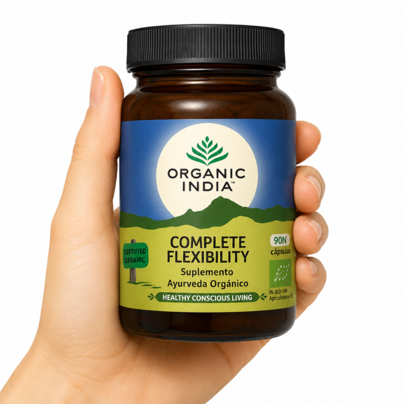 Organic India Complete Flexibility sostenido por una mano sobre fondo blanco, suplemento ayurvédico orgánico para articulaciones y movilidad.