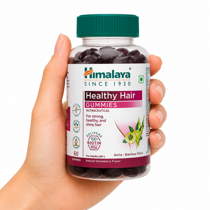 Bote de Healthy Hair Gummies Himalaya sostenido por una mano sobre fondo blanco, gominolas con biotina, amla y sílice de bambú para el cuidado del cabello.