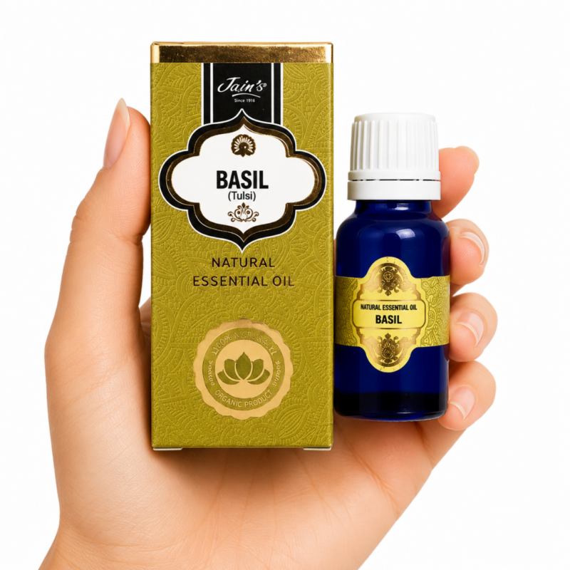 Aceite Esencial de Basil (Tulsi) Jain's 100% natural con caja verde y frasco de vidrio azul sobre fondo blanco.