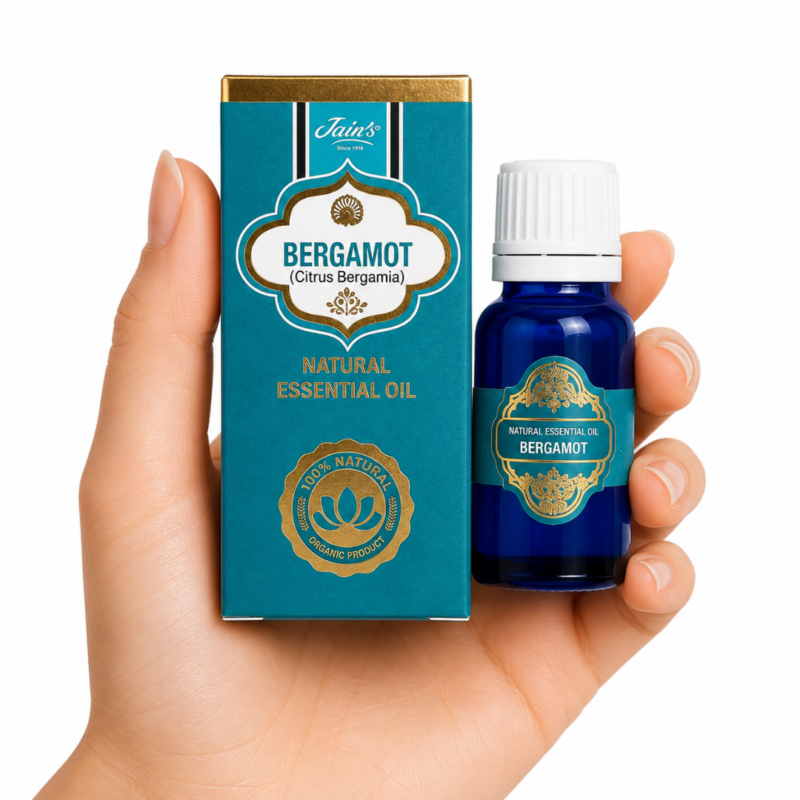 Aceite Esencial de Bergamota Jain's 100% natural con caja azul turquesa y frasco de vidrio azul sobre fondo blanco.