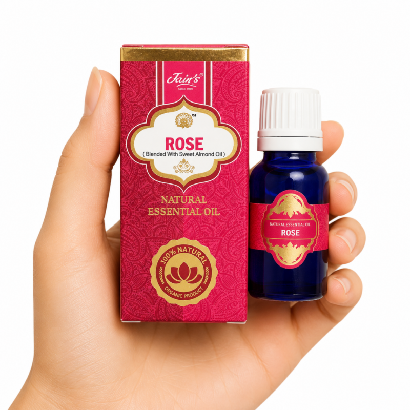 Aceite Esencial de Rosa (Rose) Jain's 100% natural con caja rosa y frasco de vidrio azul sobre fondo blanco.