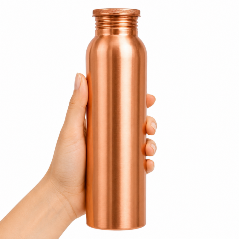Botella de cobre lisa de 950 ml para agua inspirada en la tradición ayurvédica sobre fondo blanco minimalista.