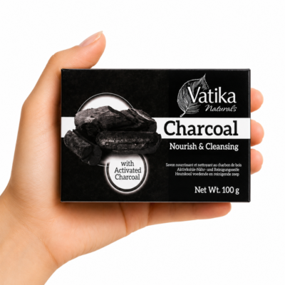 Mano sosteniendo Jabón Vatika Naturals Charcoal 100 g sobre fondo blanco. Jabón purificante con carbón activado para limpiar y desintoxicar la piel.