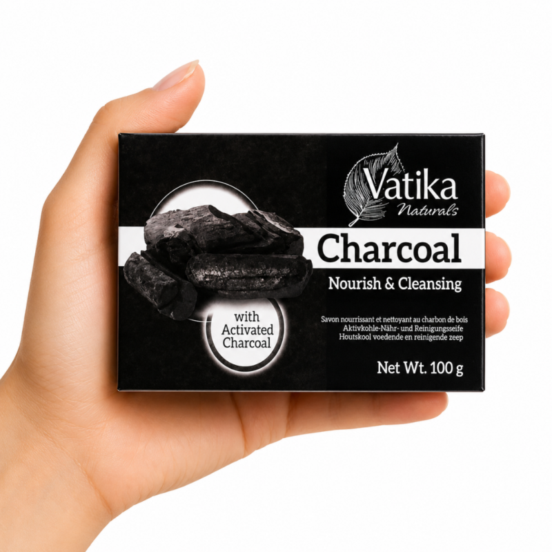 Mano sosteniendo Jabón Vatika Naturals Charcoal 100 g sobre fondo blanco. Jabón purificante con carbón activado para limpiar y desintoxicar la piel.