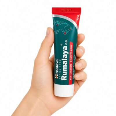 Mano sosteniendo el Gel Rumalaya Himalaya de 50 g junto a su caja original sobre fondo blanco.