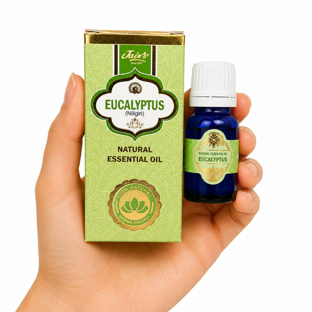TGL 26 01 - Web - PWP-JAI-0019 - Aceite Esencial de Eucalipto * Mano sosteniendo el Aceite Esencial de Eucalipto Jains junto a su caja original sobre fondo blanco.