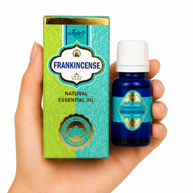 * Mano sosteniendo el Aceite Esencial de Frankincense Jains junto a su caja original sobre fondo blanco.