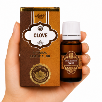 * Mano sosteniendo el Aceite Esencial de Clavo Jains junto a su caja original sobre fondo blanco.