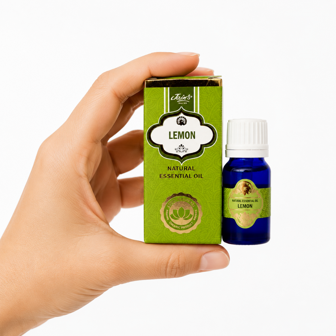 TGL 26 01 - Web - PWP-JAI-0042 - Aceite Esencial de Limón * Mano sosteniendo el Aceite Esencial de Limón Jains junto a su caja original sobre fondo blanco.