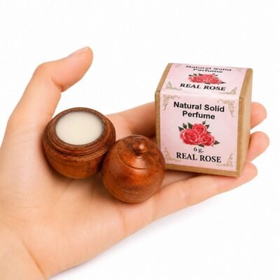Mano sosteniendo el Perfume Sólido Natural Orchid Jains de 6 g con envase de madera y caja original sobre fondo blanco.