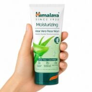 Mano sosteniendo el Limpiador Facial Hidratante Aloe Vera de Himalaya sobre fondo blanco.