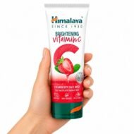 Limpiador Facial de Fresa con Vitamina C de Himalaya sostenido en una mano sobre fondo blanco