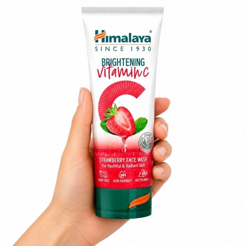 Limpiador Facial de Fresa con Vitamina C de Himalaya sostenido en una mano sobre fondo blanco