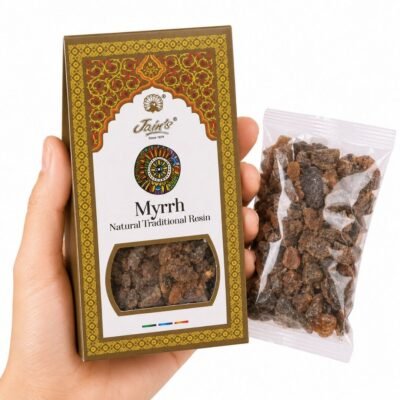 Mano sosteniendo Mirra Myrrh Resin de Jain’s con caja y resina aromática tradicional sobre fondo blanco