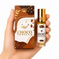 Mano sosteniendo Choco Vanilla Attar 8 ml de Jain’s con caja, perfume concentrado de chocolate y vainilla
